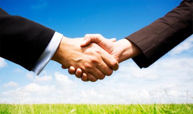 business_opp Two people shaking hands in a field