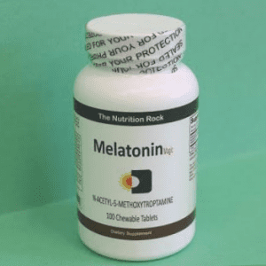 Melatonin dietary supplement bottle on green background.