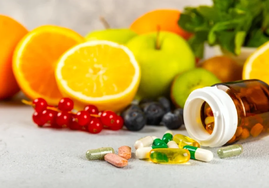A table topped with fruits and pills next to it.