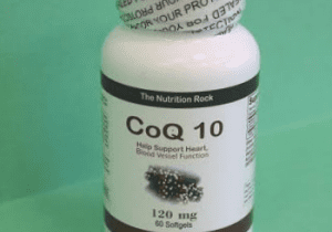 CoQ10 dietary supplement bottle on green background.