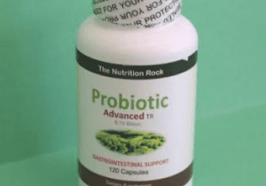 Probiotic supplement bottle on green background.