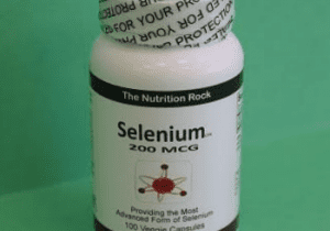 Selenium dietary supplement bottle on green background.
